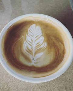 view of coffee from top with leaf design in foam