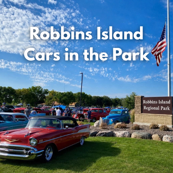 classic cars parked around the Robbins Island entrance sign