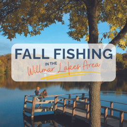 two men fishing on a pier with fall colors around the lake
